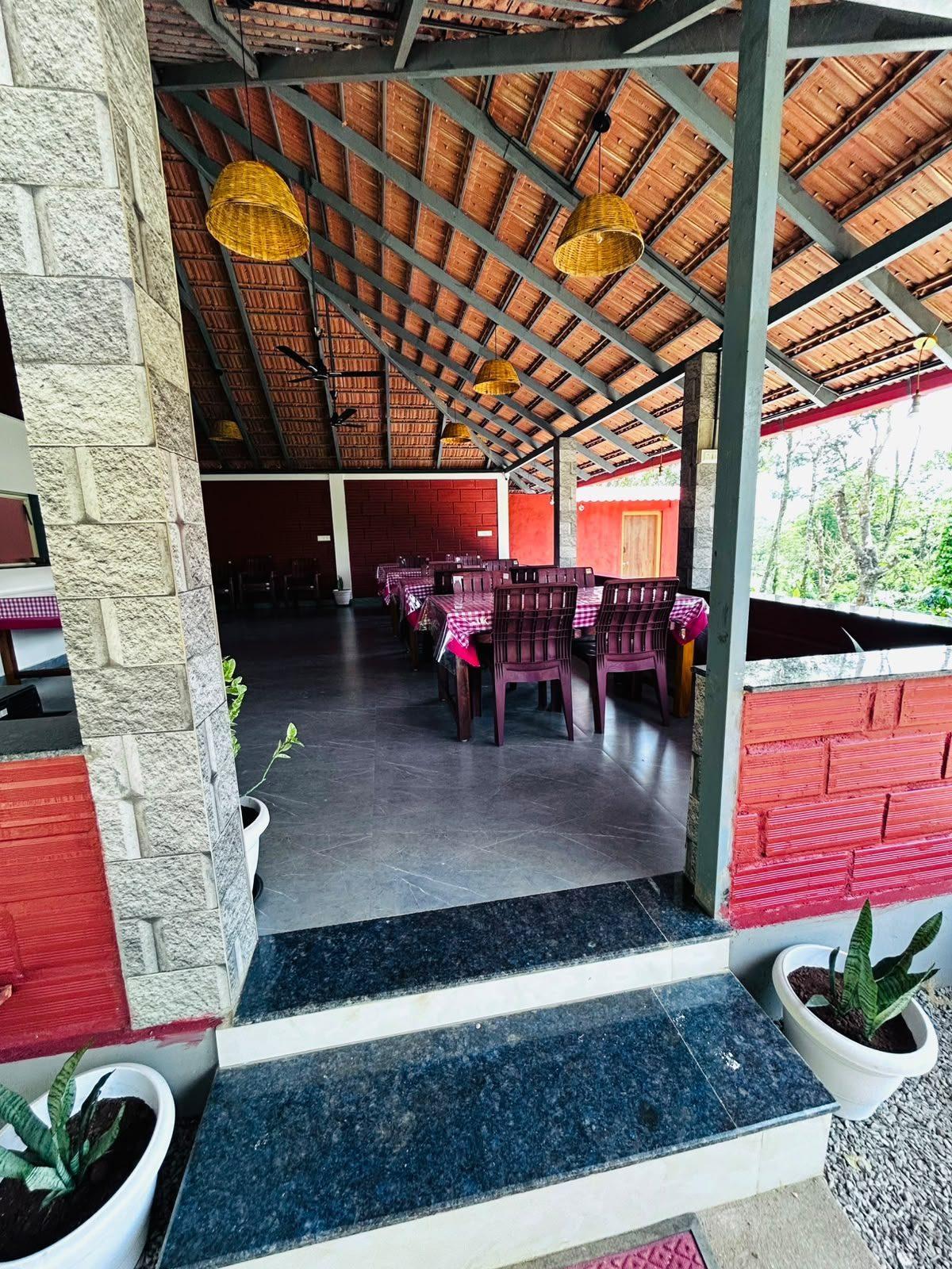 Open dining hall with a sloping tiled roof, wicker lamps and set tables